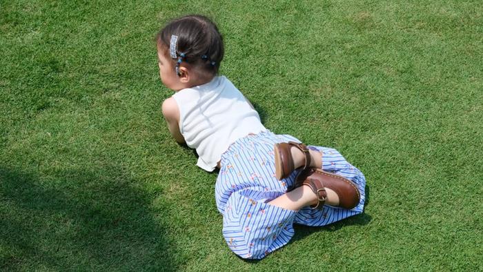 Hình nền bé gái cute nằm trên bãi cỏ